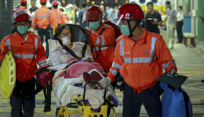 An injured ferry passenger is escorted by rescuers after getting onshore in Hong Kong. Reuters 