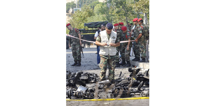 A soldier takes pictures yesterday at the site of the blast in Beirut.
