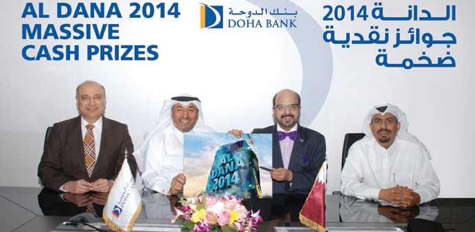 Doha Bank officials display the Al Dana 2014 campaign poster.