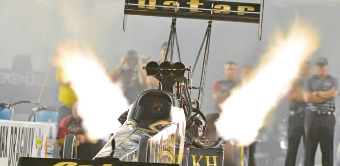 The Qatar Al-Anabi Racing gold Top Fuel car blasts off the starting line as driver Khalid al-Balooshi makes his second run at zMAX Dragway in Charlott
