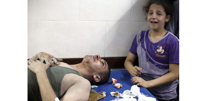A Palestinian girl crying as her father, wounded in an Israeli air strike on the al-Shati refugee camp, is treated at the al-Shefa hospital in Gaza Ci