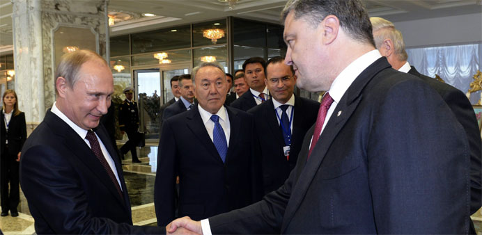Russian President Vladimir Putin (2-L) shaking hands with Ukrainian President Petro Poroshenko (R).  -EPA