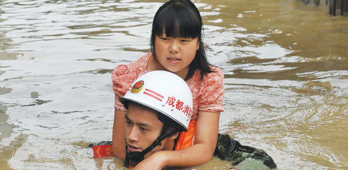 A rescuer brings a woman to safety as the Tuo river floods Jintang county, southwest Chinau2019s Sichuan province.