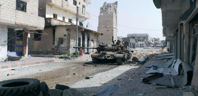 An abandoned tank is seen on a street near the minaret of the Omari mosque, which was destroyed by what activists said was shelling by regime forces, 