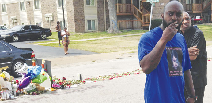 Michael Brown Sr walks from the makeshift memorial set up to honour his son, Michael, who was fatally shot by a white police officer 13 days ago in Fe