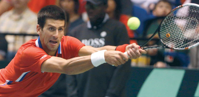 Novak Djokovic hits a return to John Isner of the US during their Davis Cup quarter-final