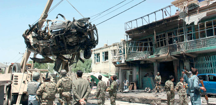 US soldiers and Afghan security officials inspect the scene of a suicide car bomb attack targeting a convoy of Nato forces in Kabul yesterday.