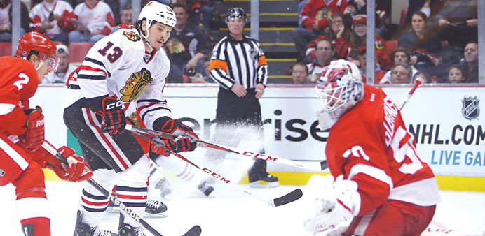 Daniel Carcillo (13) of Chicago Blackhawks shoots the puck during their NHL game against Detroit Red Wings, at Joe Louis Arena in Detroit on Sunday. (