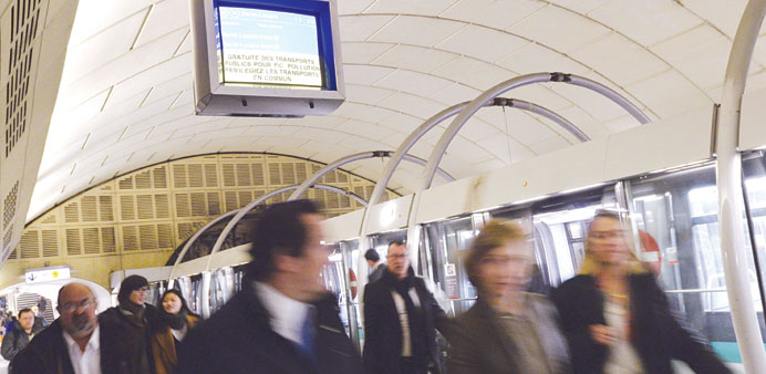 People walk past a screen reading u2018Free public transport for peak pollution. Prefer public transportu2019 at a metro station in Paris yesterday.