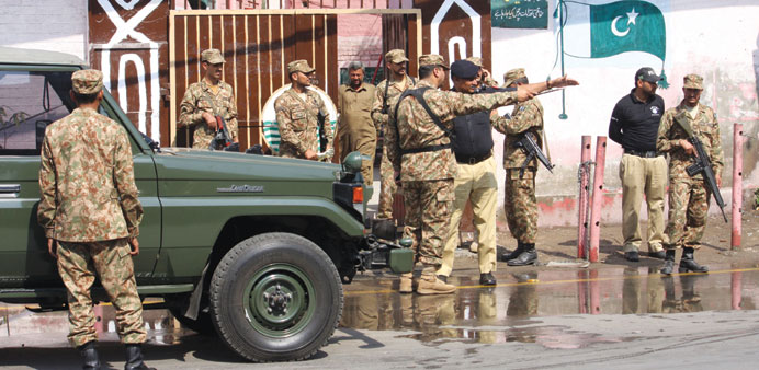 Pakistani soldiers stand guard at a polling station in Lahore.