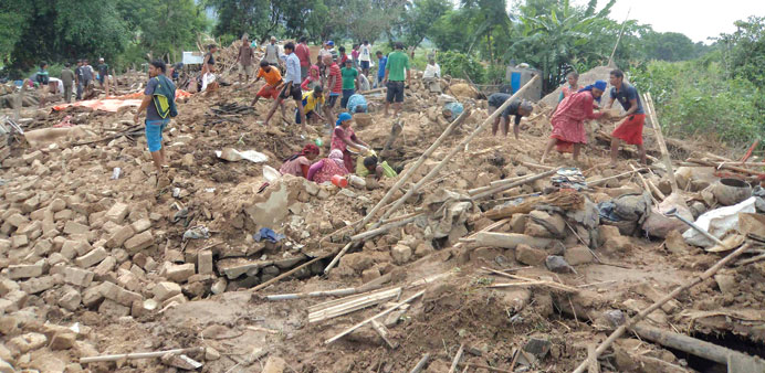 Flood victims collect their belongings from their destroyed homes at Motipur village of Dang district in eastern Nepal yesterday.