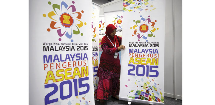 A woman sets up banners for the 26th Asean summit at the Kuala Lumpur Convention Centre, Malaysia yesterday.