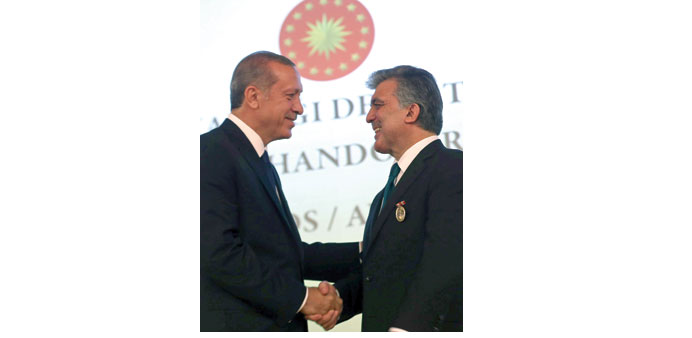President Erdogan shakes hands with predecessor Gul after decorating the latter with the State Medal of Distinguished Service during the presidential 