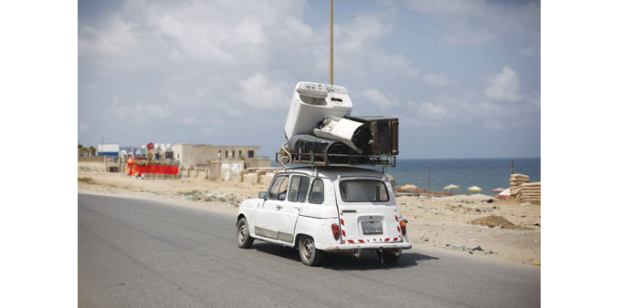 A Palestinian drives his car loaded with old household appliances yesterday in Gaza City.