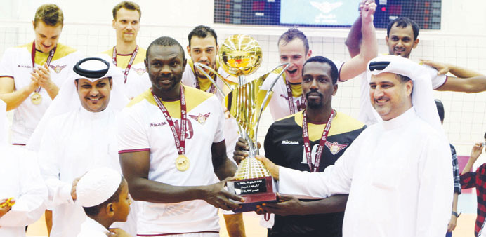 El Jaish's Mohemad Taha receives the trophy from Yusuf Ahmed Kano, assistant secretary general of Qatar Volleball Association. The defending champions
