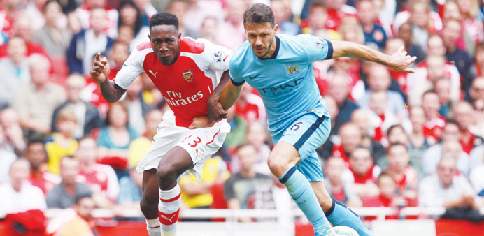 Arsenal's Danny Welbeck (left) and Manchester City's Martin Demichelis vie for the ball in London, yesterday. (EPA)