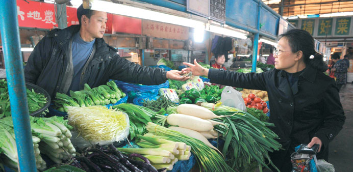 A woman buys vegetables in a market in Shanghai yesterday. The uptick in Chinau2019s economy and u201crobust growthu201d in Southeast Asia would lead expansion, t