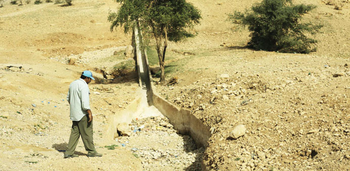 A man walking next to a dried-out gulley usually flowing with natural spring water in the Palestinian village of al-Auja, near the West Bank city of J