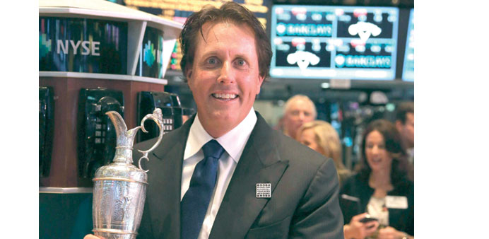British Open golf champion Phil Mickelson holds the Claret Jug on the floor of the New York Stock exchange on Friday.