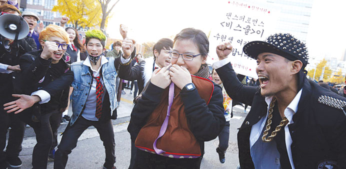 A dance performance team cheers for a student taking the annual college entrance examinations in front of an exam hall in Seoul.