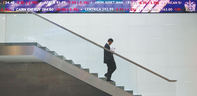    A man walks down steps under a share price ticker at the London Stock Exchange (file). The FTSE 100 index of leading shares yesterday climbed 0.69%