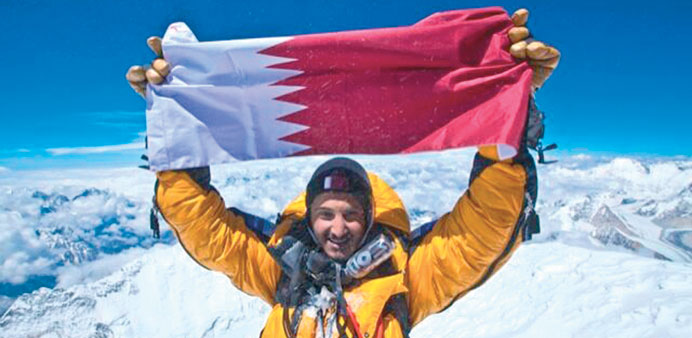 Sheikh Mohamed holds up the Qatari flag after reaching the summit of Mount Everest.