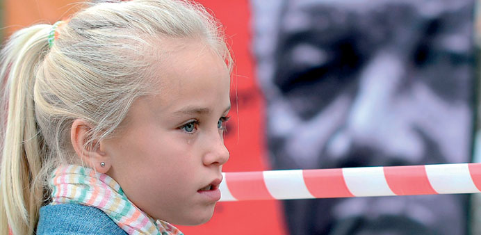A girl cries by a Nelson Mandela portrait outside the Medi Clinic Heart Hospital.