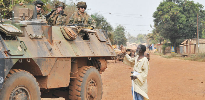 Sheick Dahoud (C), a resident of the Miskine neighborhood in Bangui, asks French soldiers for assistance in locating family members yesterday.