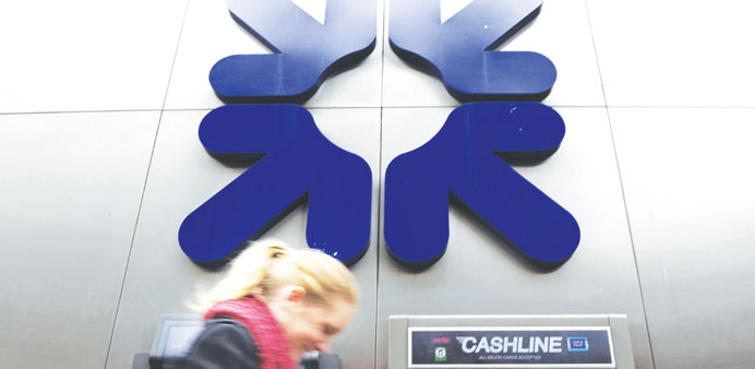 A woman walks past a RBS branch in the City of London yesterday,