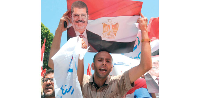 A man holds up a poster of Mursi during the rally in Tunis yesterday.