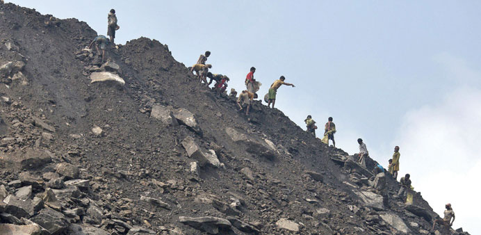 Locals collect coal from the dump site of an open coal field at Dhanbad district in Jharkhand.