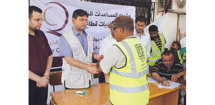 A Palestinian government employee receives monetary assistance from Qatar Charity.