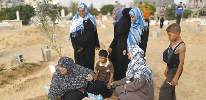A woman mourns next to the grave of her son, who was killed during the Israeli offensive, at a cemetery in Beit Lahiyah in the northern Gaza Strip yes