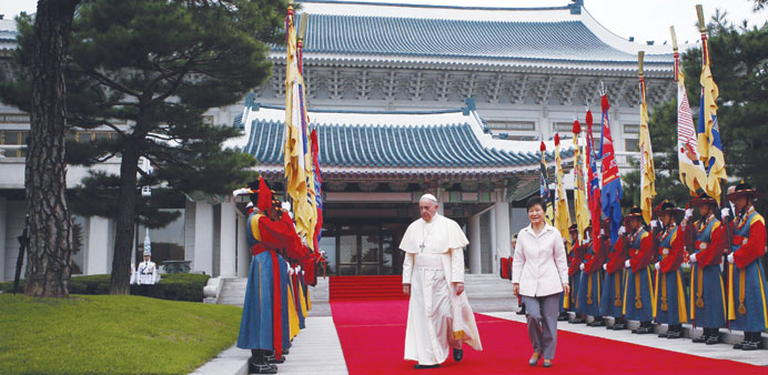South Korean President Park Geun-hye walks with Pope Francis at the presidential Blue House in Seoul.