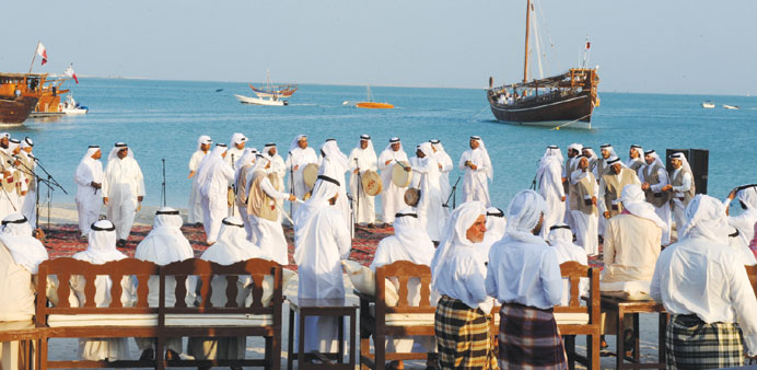 A cultural performance being staged for the members of the Fath Al Kheir (background, right) voyage.