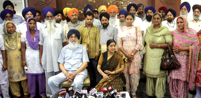 External Affairs Minister Sushma Swaraj and Punjab Chief Minister Parkash Singh Badal sit in front of the relatives and family members of India worker