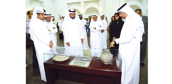 Jassim Telefat (centre), along with fellow guests, viewing artefacts at the u2018Arabic Scriptu2019 exhibition at QF.