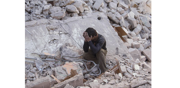 A boy mourns in the rubble of a building following a reported air strike by government forces in Aleppo yesterday.