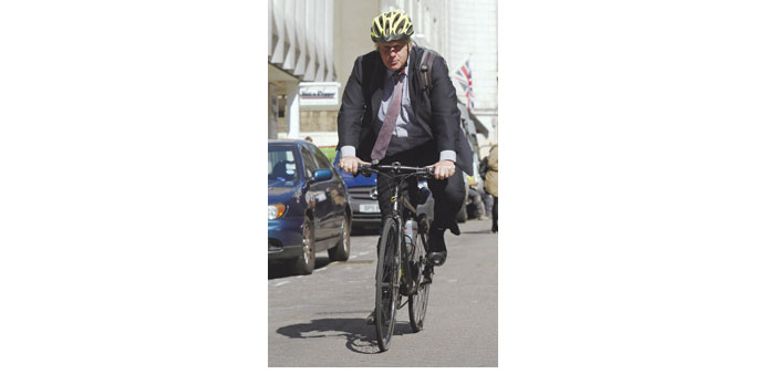 London mayor Boris Johnson cycles off after speaking to members of the media in central London yesterday.