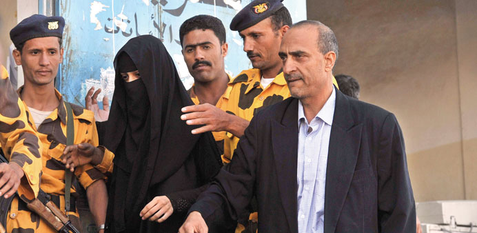 Soldiers escort Huda al-Niran and her lawyer Abdel Rakib al-Qadi outside the court in Sanaa yesterday.