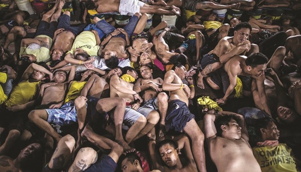 This picture taken on July 21, 2016 shows inmates sleeping inside the Quezon City jail in Manila.