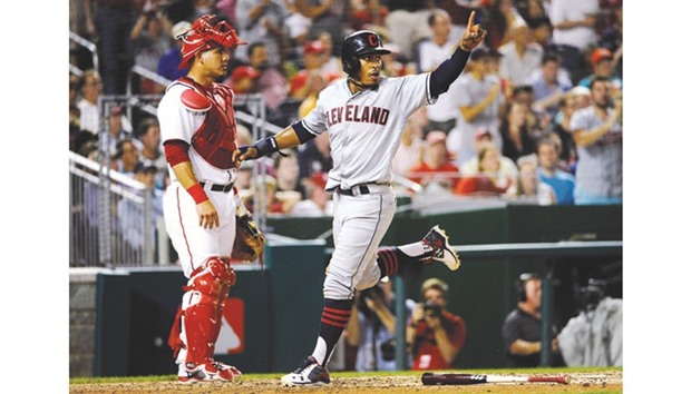 Cleveland Indians shortstop Francisco Lindor (right) reacts after scoring a run as Washington Nationals catcher Wilson Ramos looks on during the seventh inning at Nationals Park in Washington. (USA TODAY Sports)