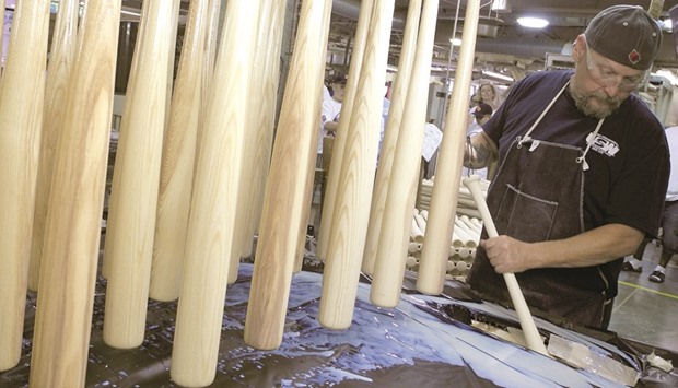 FINISHING TOUCHES:  A factory worker dipping a baseball bat into finish at the Louisville Slugger factory in Louisville, US. 1.8 million baseball bats are produced at the Louisville Slugger Museum and Factory. Visitors can learn about the history of the company in the museum next door.