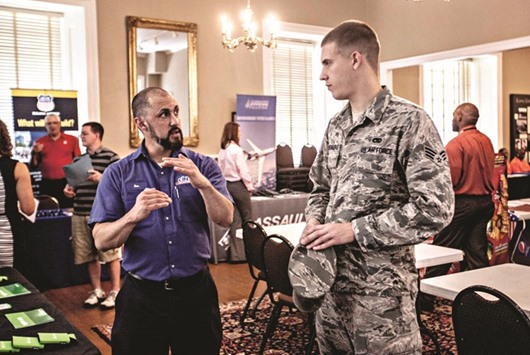 A job seeker (right) speaks with a representative with Cintas Corp, during the Veterans Career Fair at the MacArthur Museum in Little Rock, Arkansas. Jobless claims fell by 1,000 to 266,000 in the week ended August 6, from a revised 267,000 in the prior period, a report from the Labor Department showed yesterday.