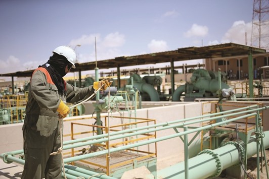 A worker maintains oil pipelines at the Zueitina oil terminal in Zueitina, west of Benghazi (file). Libya, which holds Africau2019s largest oil reserves, has seen its output hobble to 207,000 bpd this week from a peak of 1.6mn bpd before it descended into civil war.