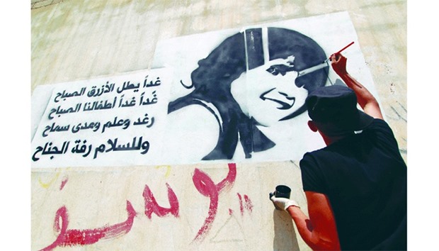 A Yemeni paints the face of a child on a wall in the capital Sanaa to raise awareness about the death and exploitation of children in war. The writing in Arabic is part of the lyrics of a Lebanese song about children.