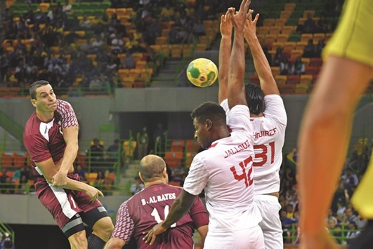 Qataru2019s Zarko Markovic (left) has his shot blocked during the menu2019s preliminaries Group A handball match against Tunisia in Rio de Janeiro yesterday. (AFP)
