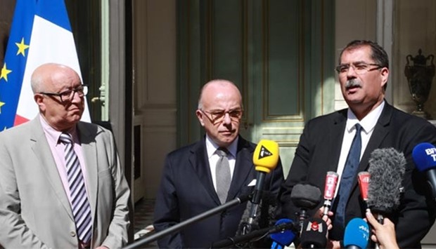 Head of the French Muslim Council Anouar Kbibech (right) speaks to journalists alongside the council's vice president Abdallah Zekri (left) and France's Minister of the Interior Bernard Cazeneuve in Paris on Monday.