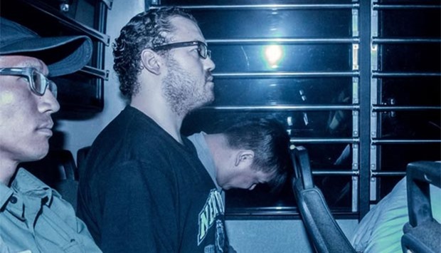 British banker Rurik Jutting (second left), accused of the murders of two Indonesian women, is seen in a prison van in Hong Kong in this May 8, 2015 file photo.