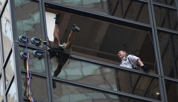 Police grab an unidentified man scaling Trump Tower, using suction cups, in New York on Wednesday.